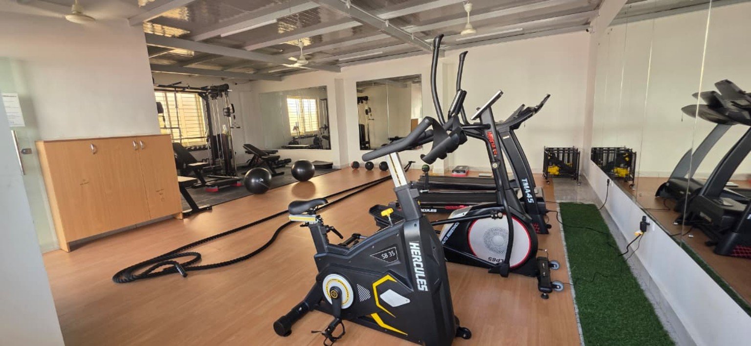 PG gym with cardio machines and mirrored walls